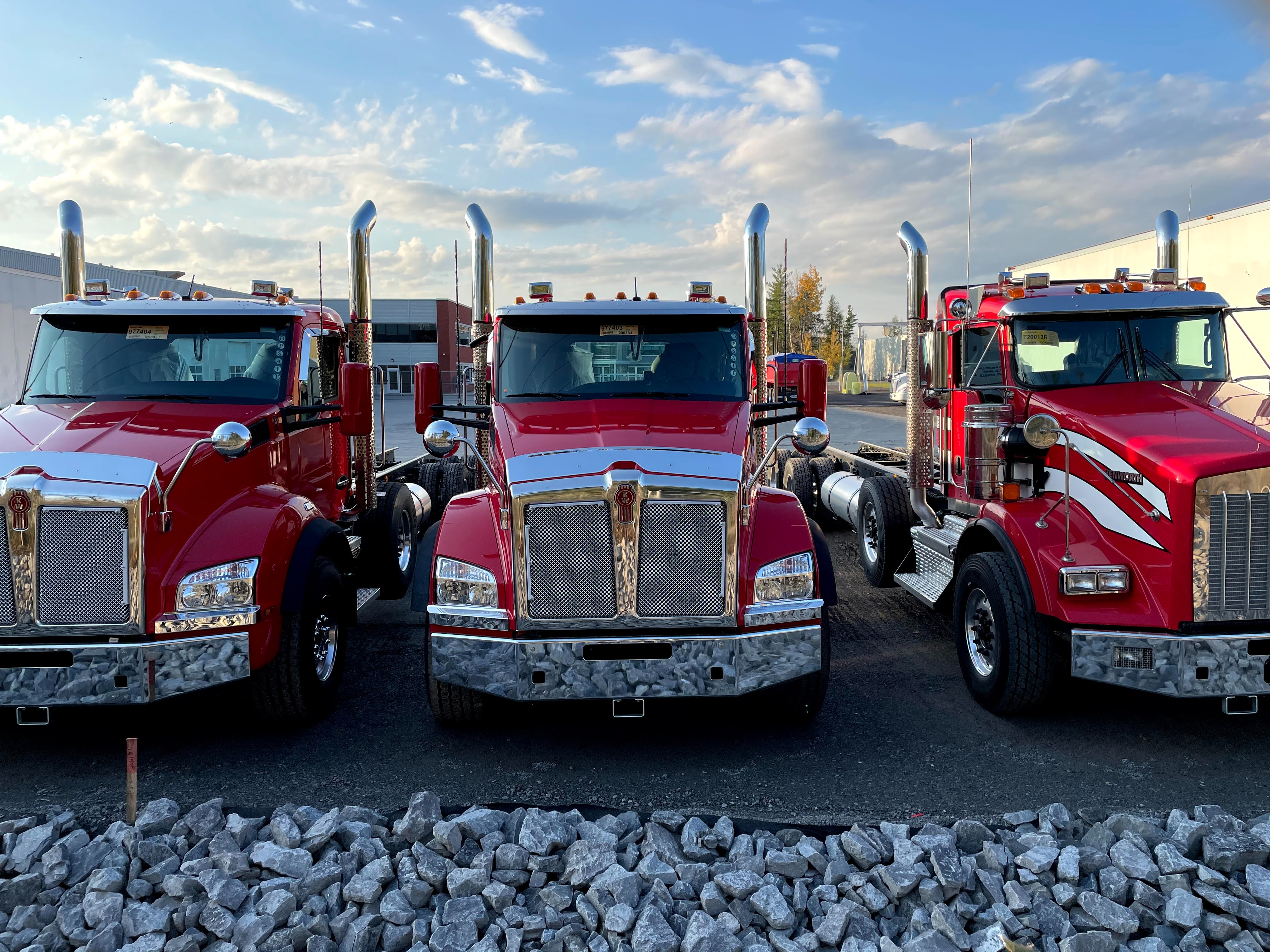 Three red semi trucks lined up representing the trucking community