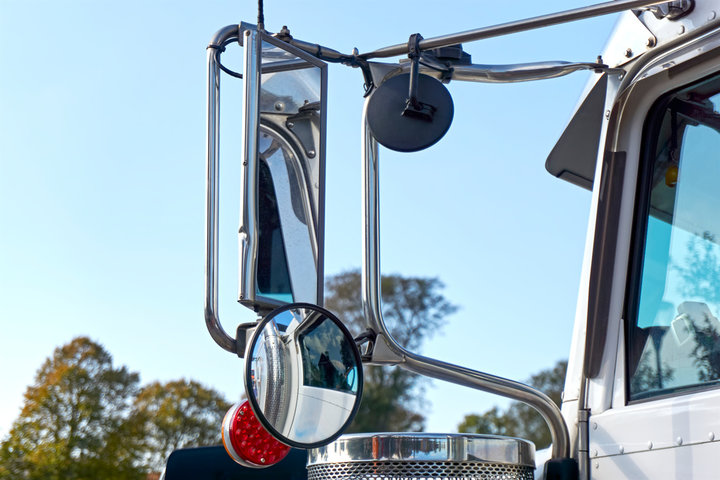 Close-up of commercial truck side mirrors representing driver safety equipment