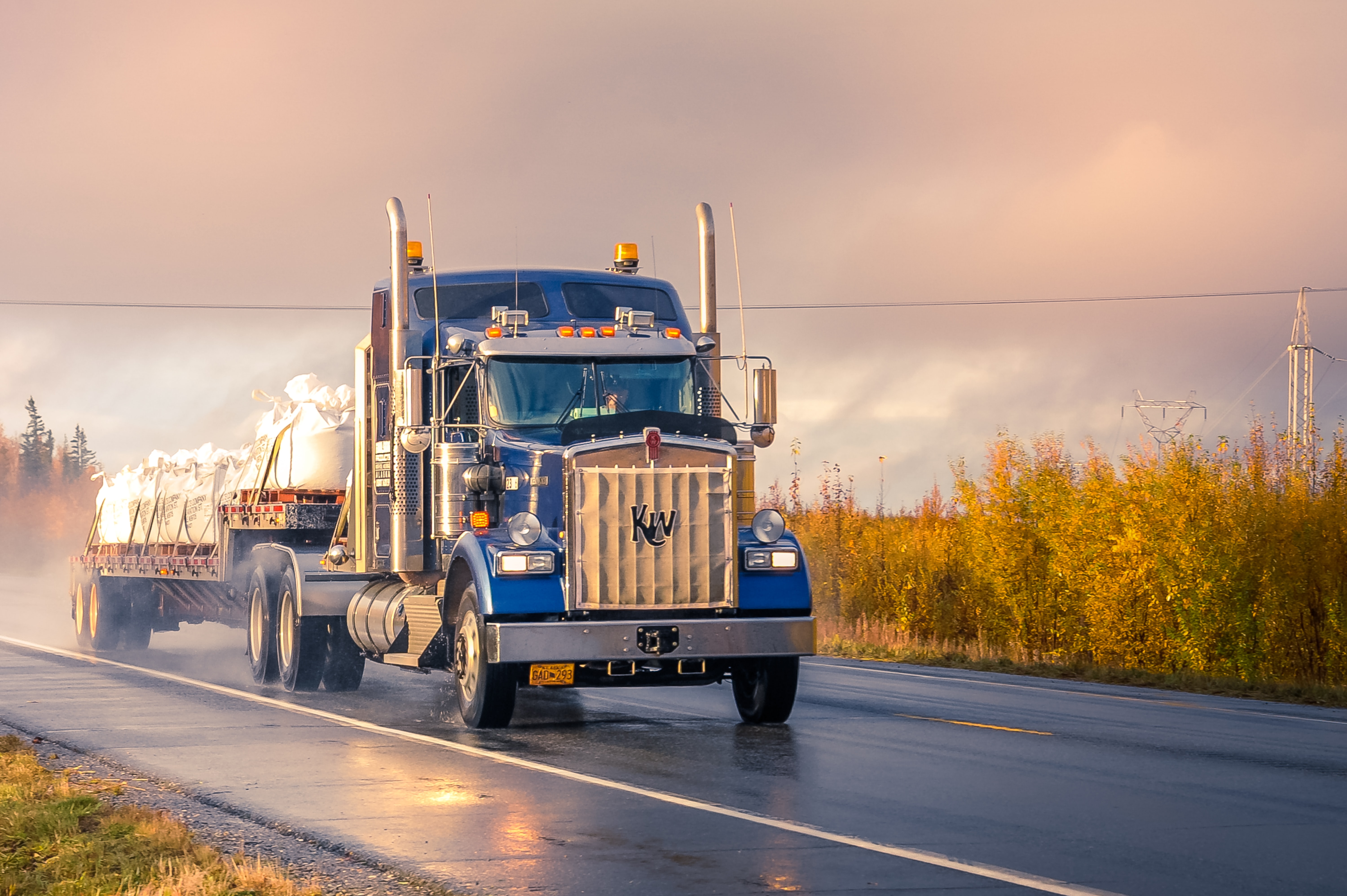 Commercial truck driving on a wet misty road with reduced visibility